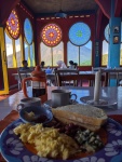 a plate of breakfast with stained glass windows behind